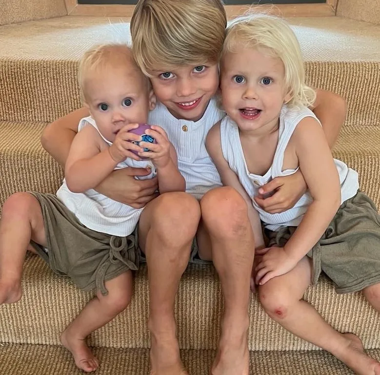 lisa curry's grandchildren flynn taj and kit hugging on a set of stairs