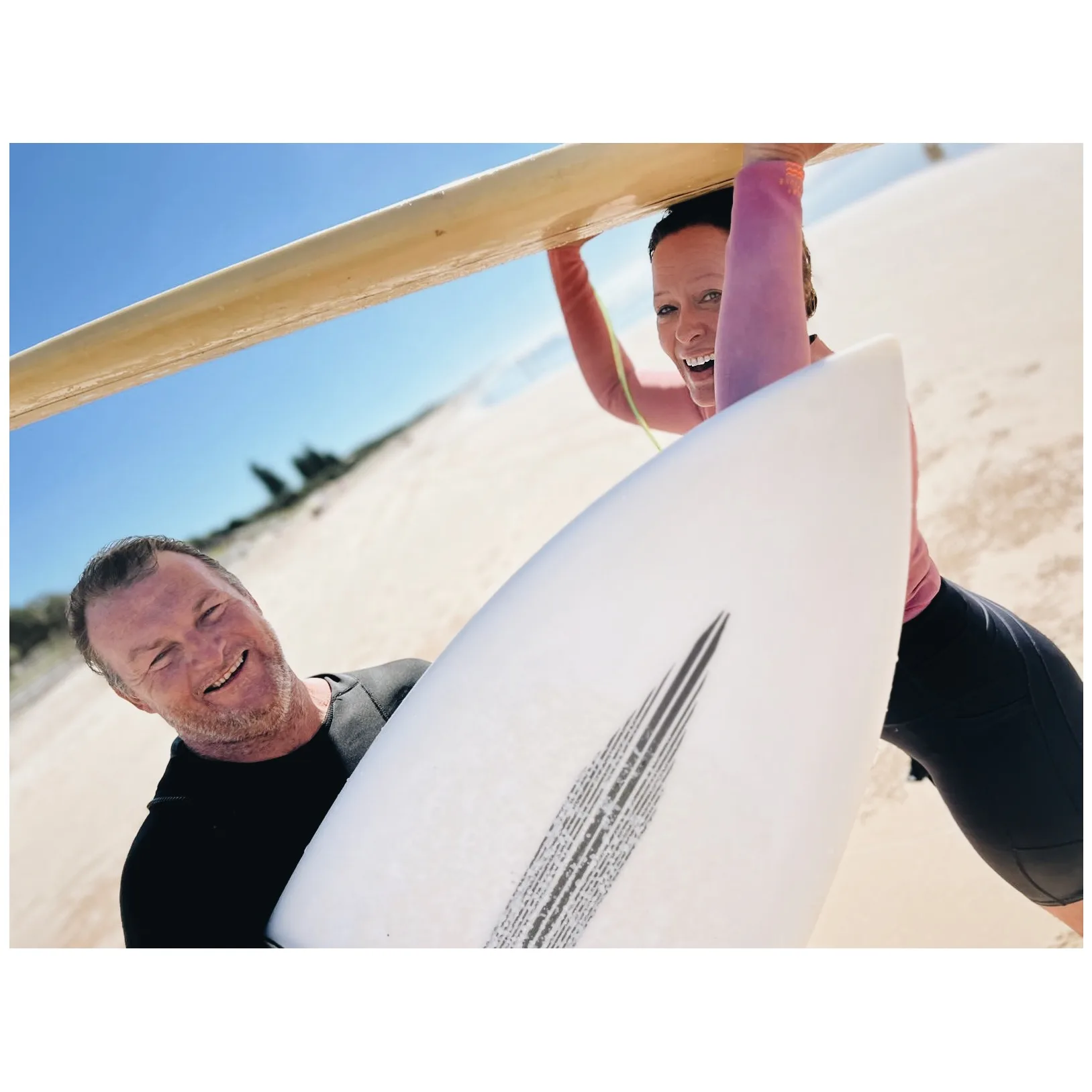 Angela cox and brother in law Trent holding surfboards