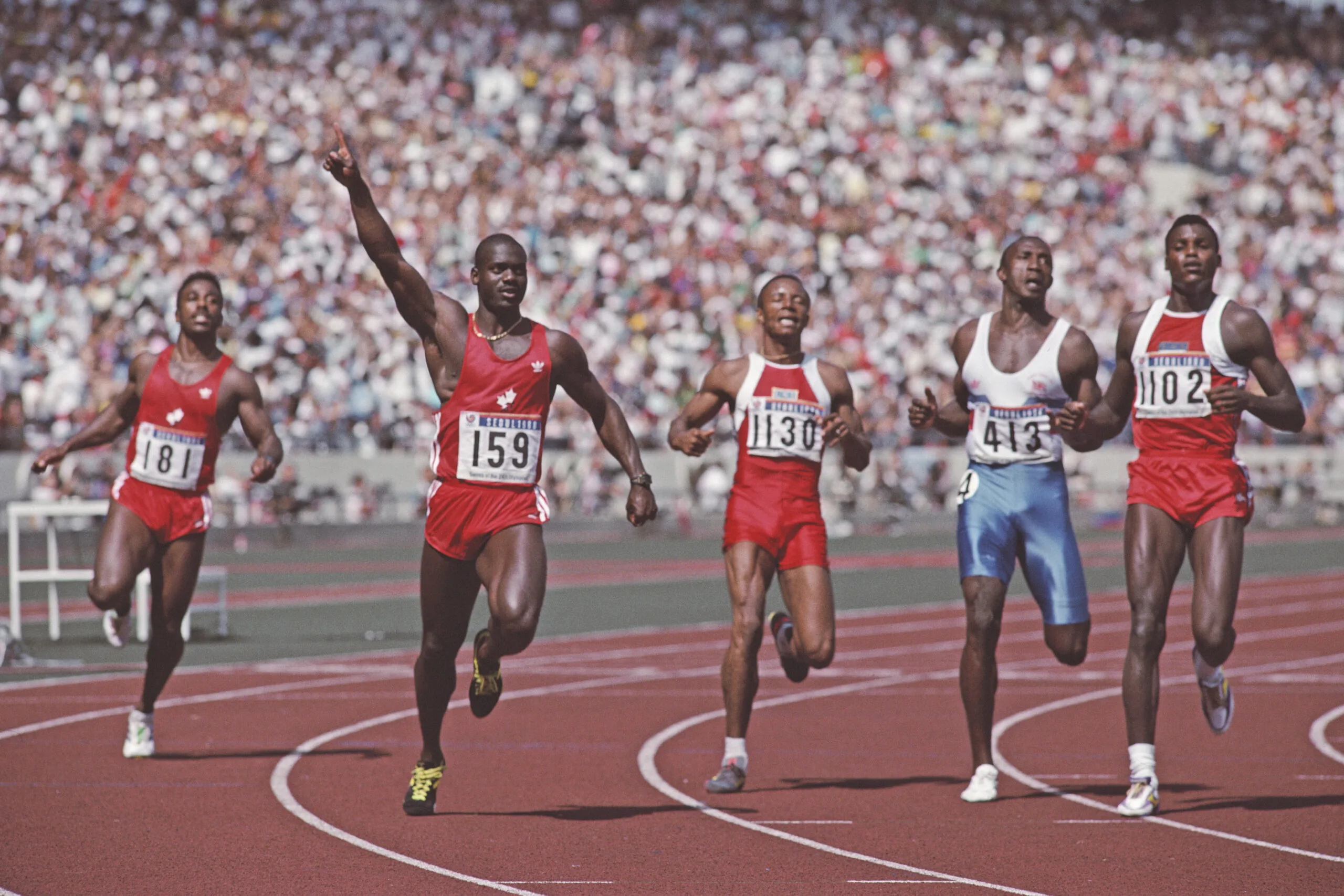 Left - right  Desai Williams look across at Ben Johnson of Canada #159 who holds his arm aloft in victory over Calvin Smith of the USA, Linford Christie of Great Britain and Carl Lewis of the USA at the finish of the Men's 100 Metres final race at the XXIV Summer Olympic Games on 24 September 1988 at the Seoul Olympic Stadium in Seoul, South Korea. Ben Johnson will be disqualified after winning the gold for taking performance drugs. (Photo by Mike Powell/Allsport/Getty Images)