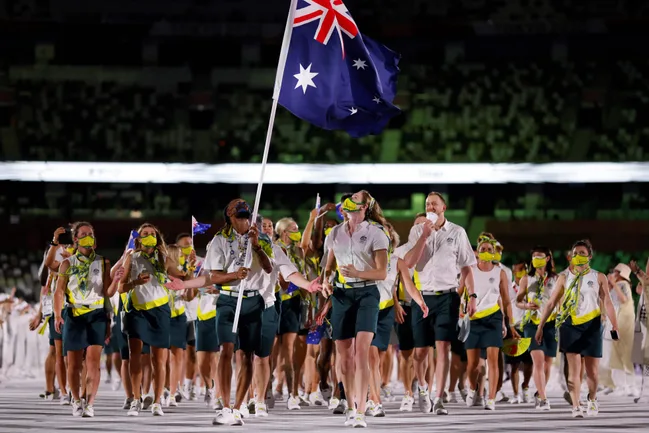 Australian athletes in masks carry the flag during the Olympic opening ceremony parade.