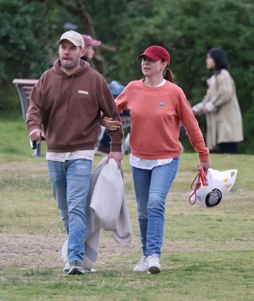Kate Ritchie and new partner Will walk together in a park.