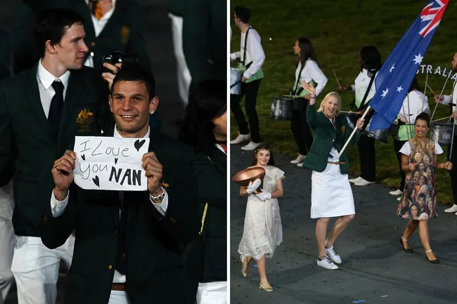 Australian athletes at an event; one holds a sign saying "I Love You Nan," another waves the Australian flag.
