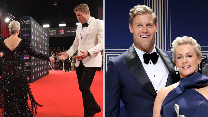 Man in tuxedo leading a woman in a sequined dress on a red carpet, both smiling at an awards event.