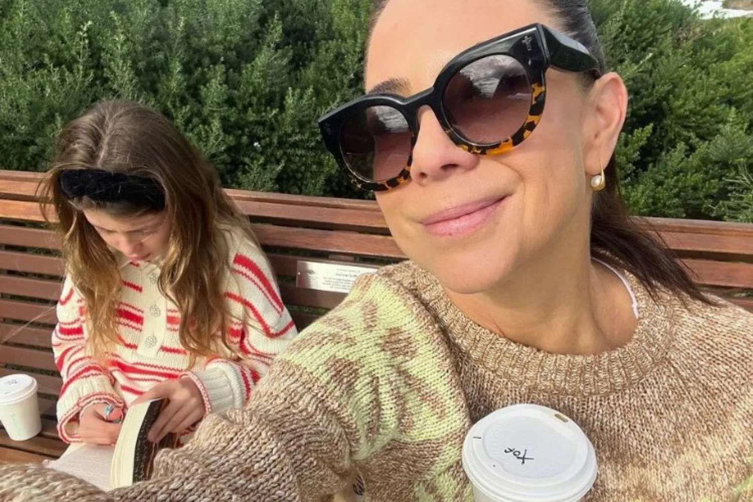 kate ritchie sitting on a park bench with her daughter mae