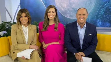 Three people sitting on a yellow couch, smiling, with a moon and star-themed backdrop.
