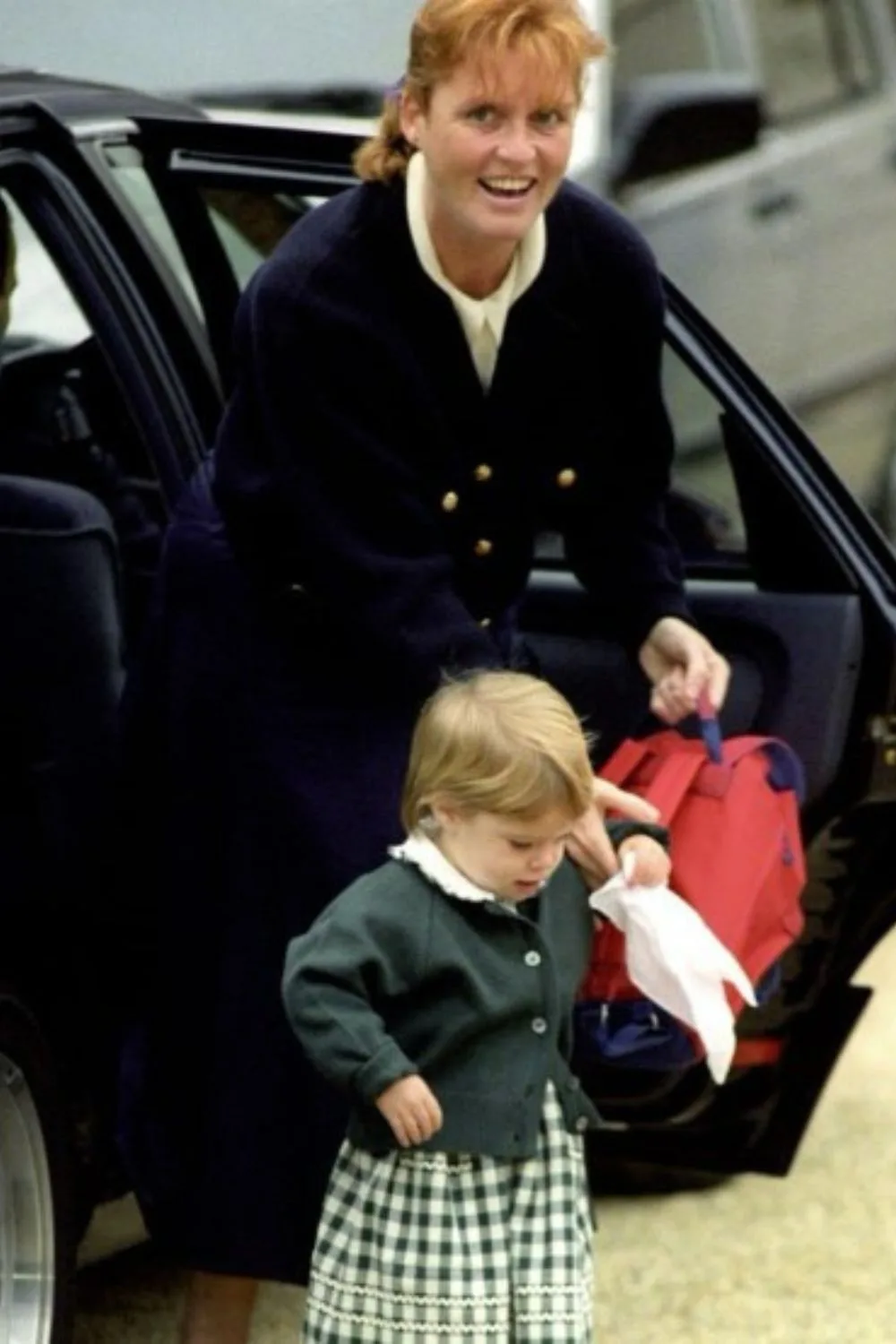 childhood photo of princess eugenie and sarah ferguson hopping out the car to go to school