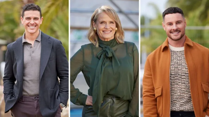 Three people smiling outdoors; one man in a blazer, a woman in a green blouse, and another man in an orange coat.