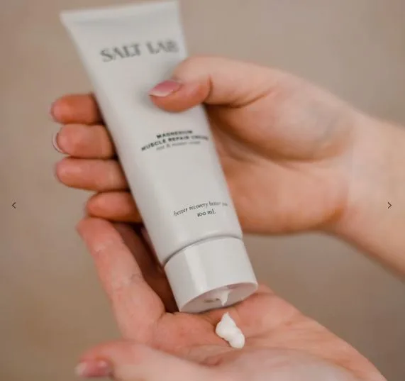 Applying cream from a "Salt Lab" tube onto a hand.