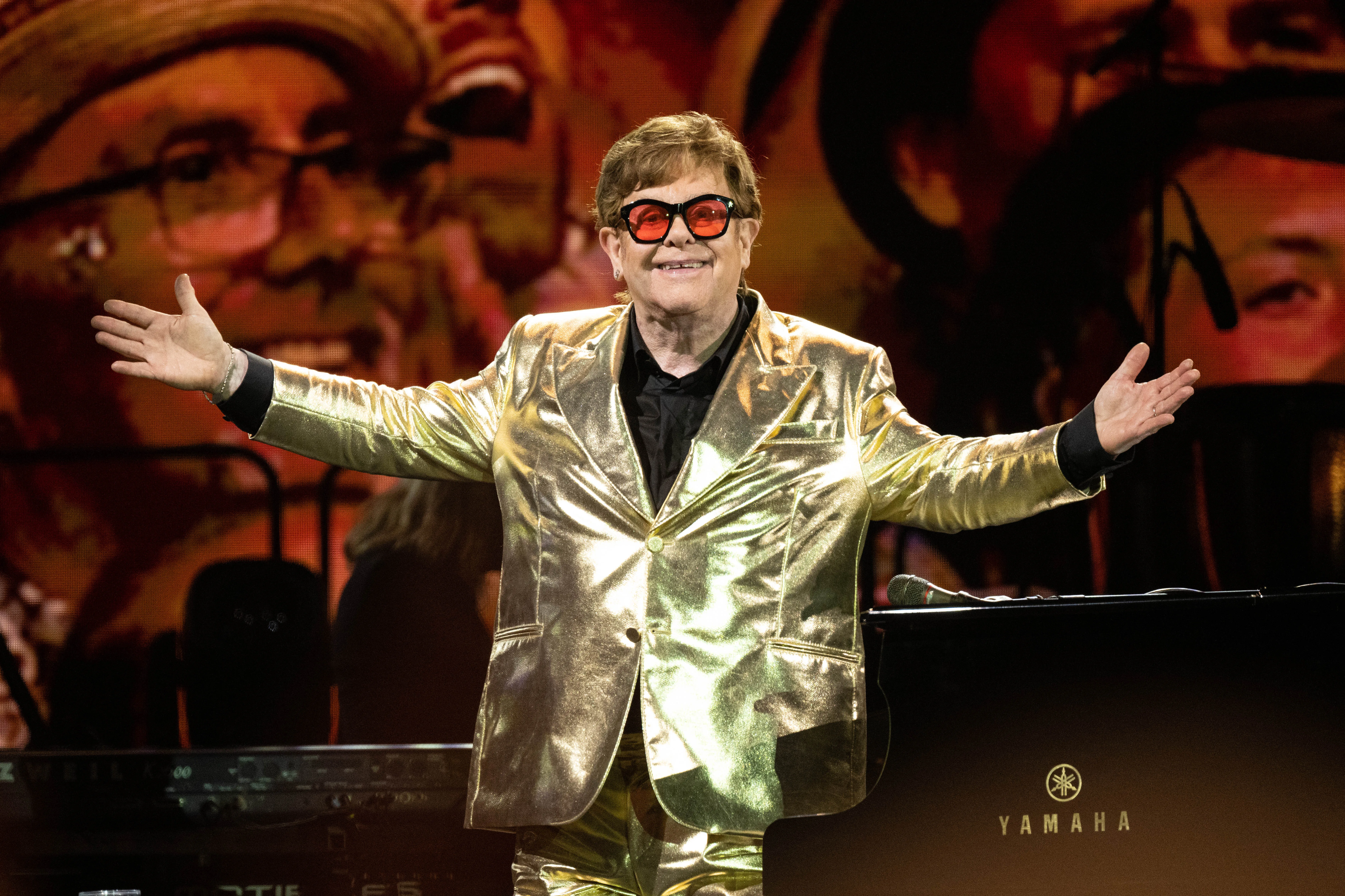 elton john in a gold suit on stage