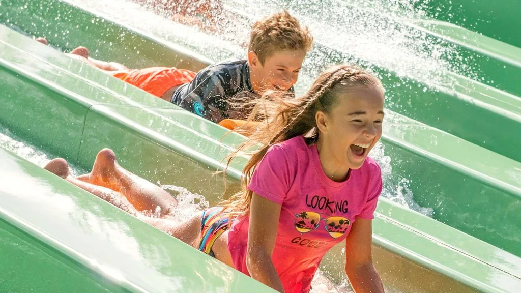 Kids going down a green waterslide at Jamberoo on the NSW South Coast.