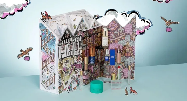 Advent calendar with beauty products displayed in a festive, illustrated house design.