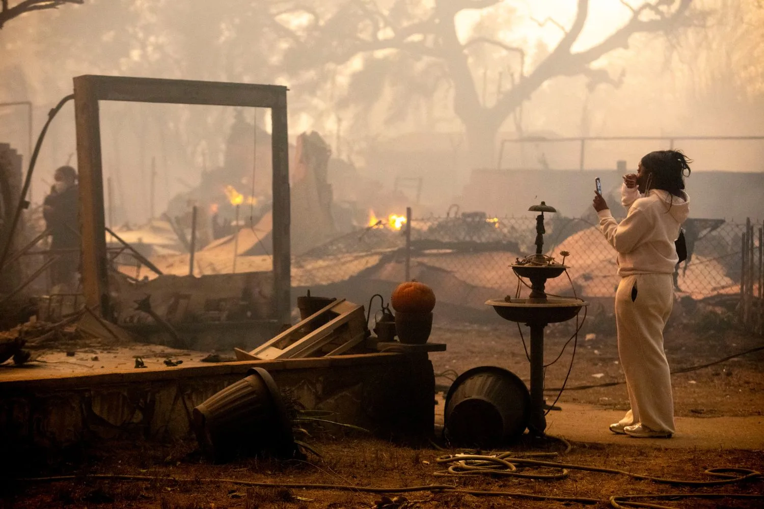 a woman looks at her burnt home during the la fires