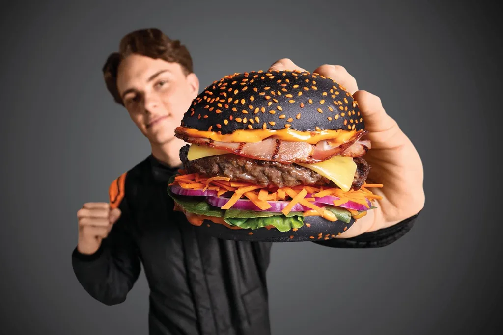 oscar piastri holding the grill'd burger