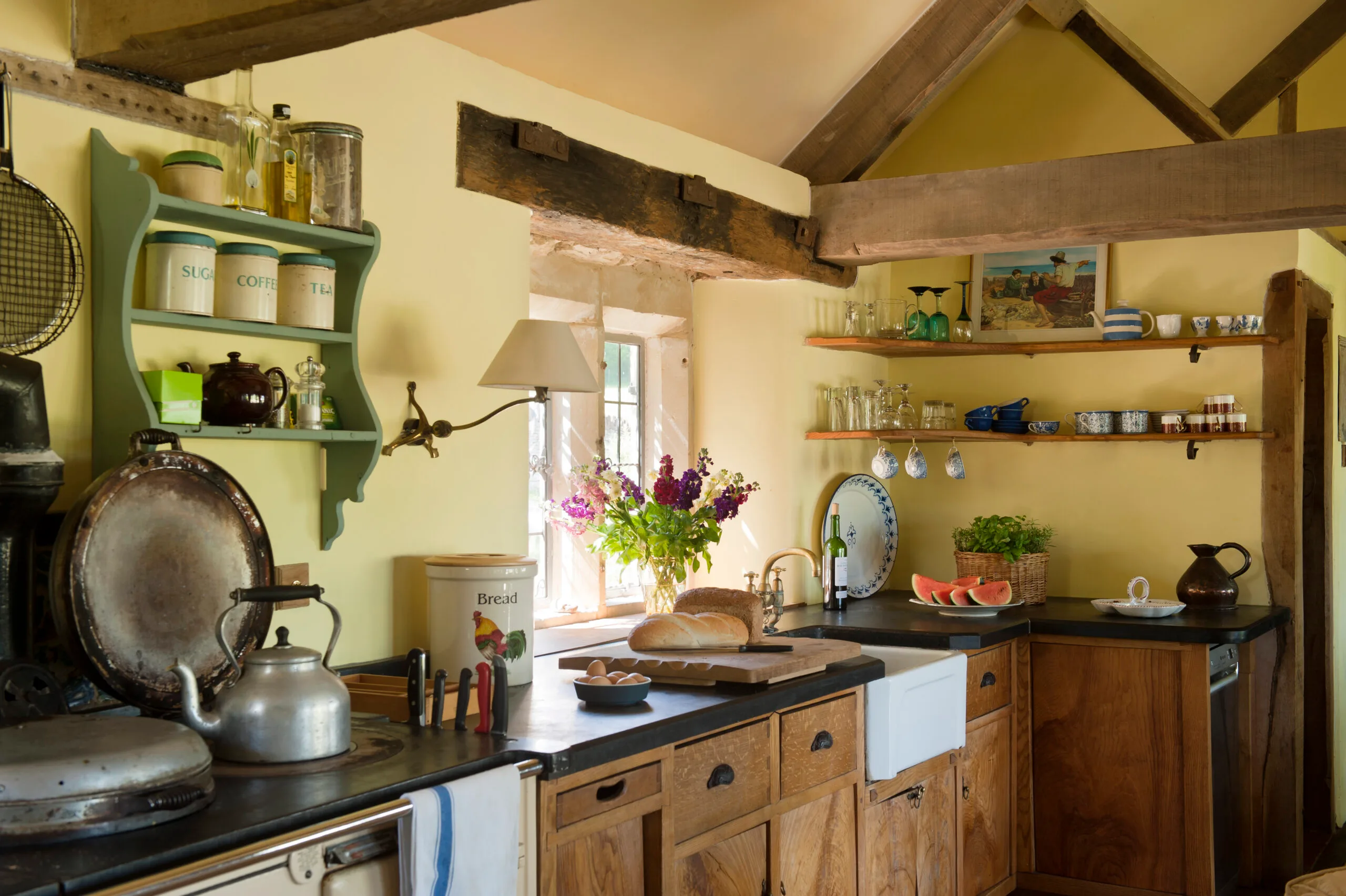 Rustic kitchen with yellow walls and wooden cupboards.