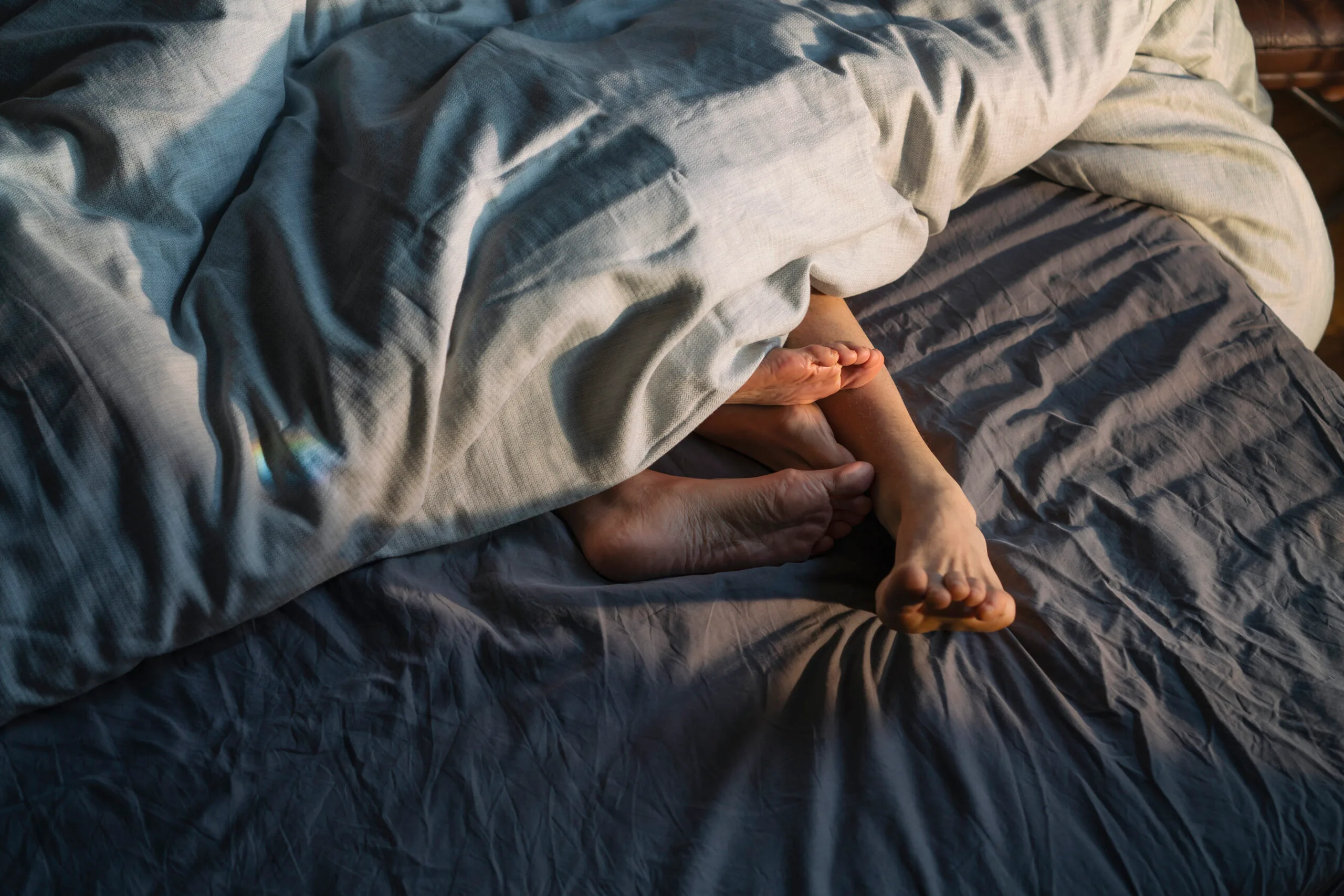 Couple's feet in bed. sex advice
