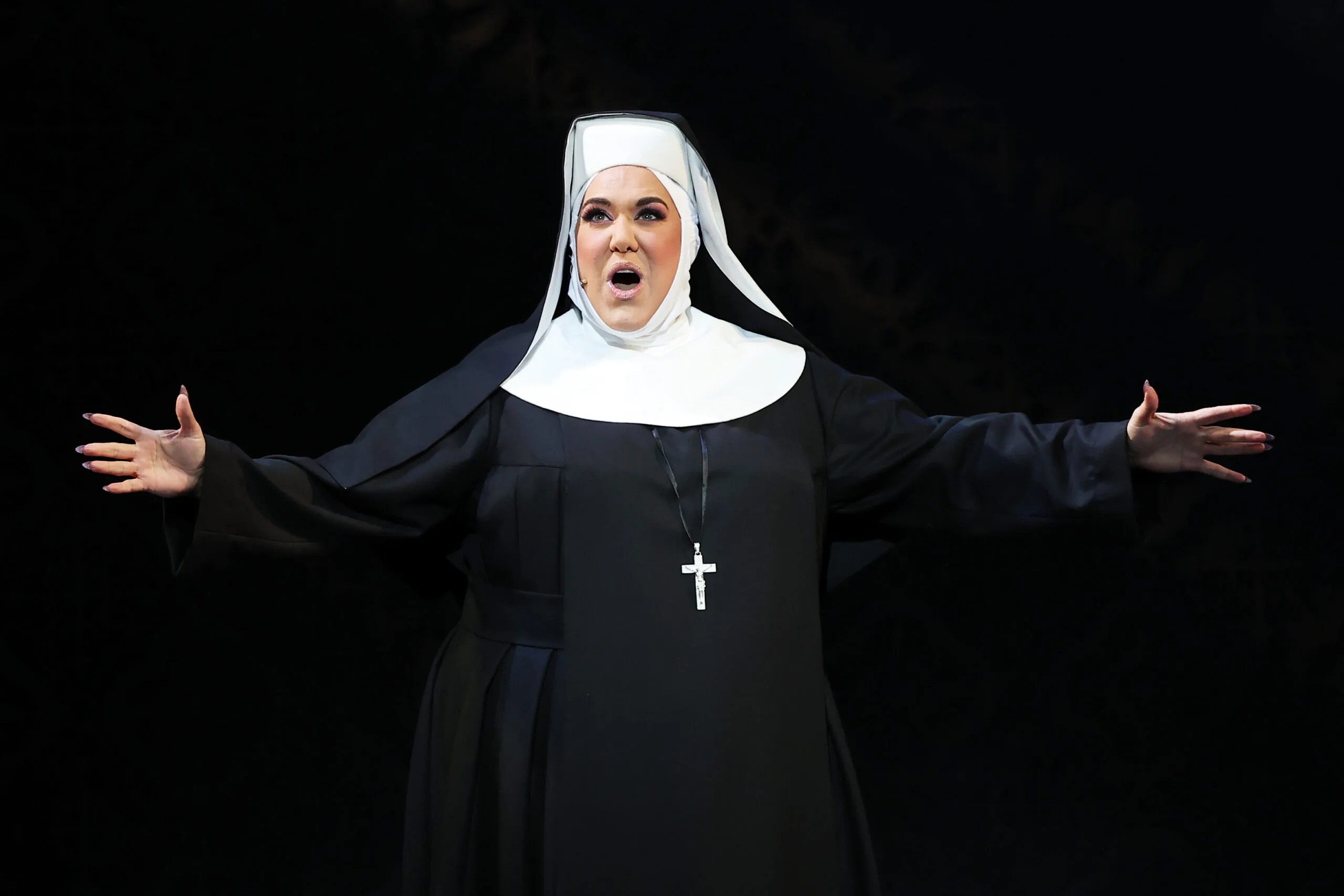 Casey Donovan wearing a nun's habit on stage in Sister Act.