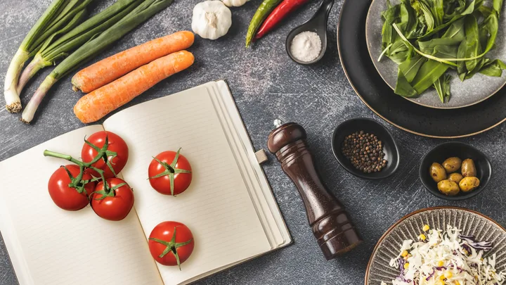 An assortment of veggies around notebook