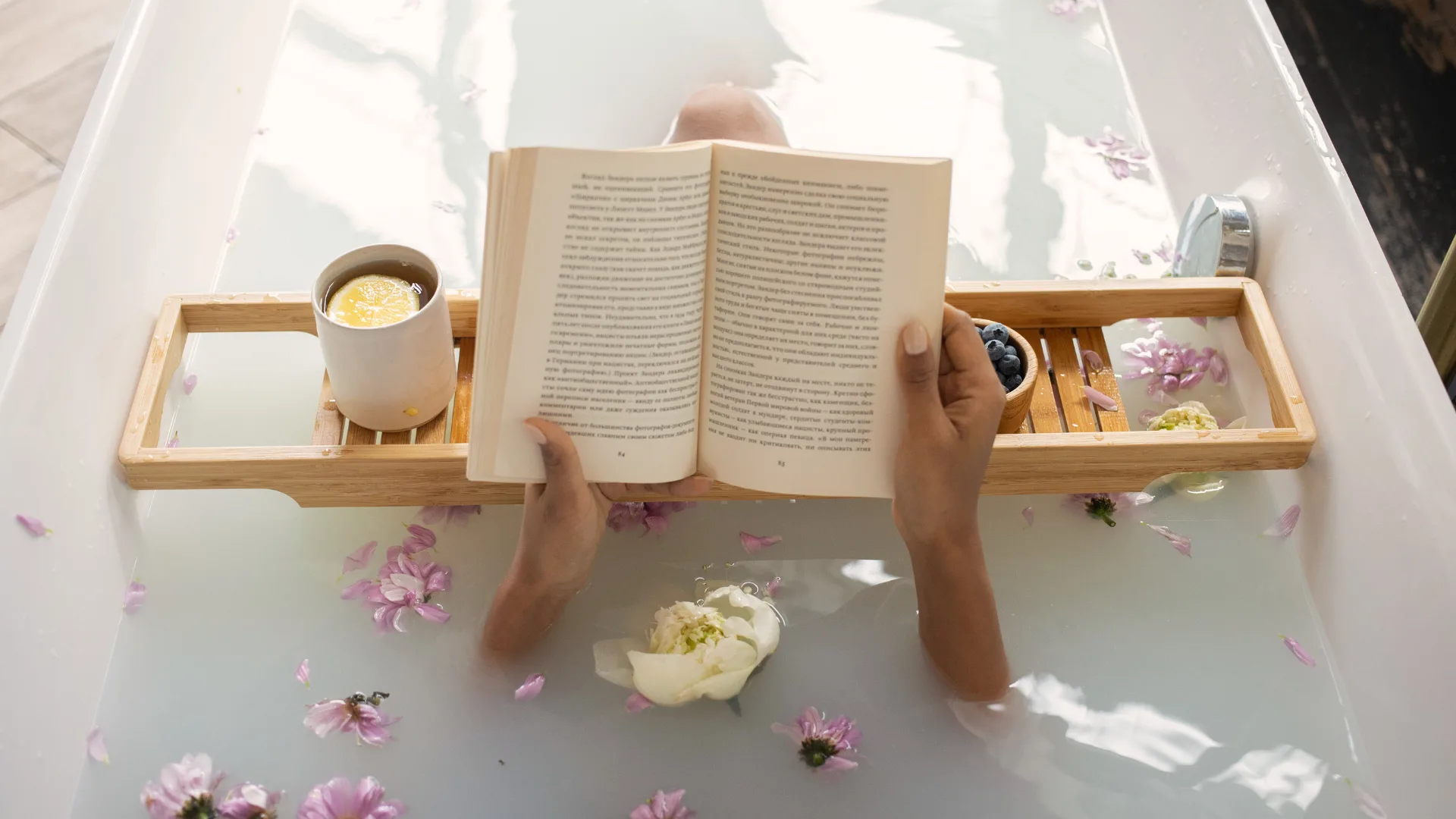 Reading book in bath tub.