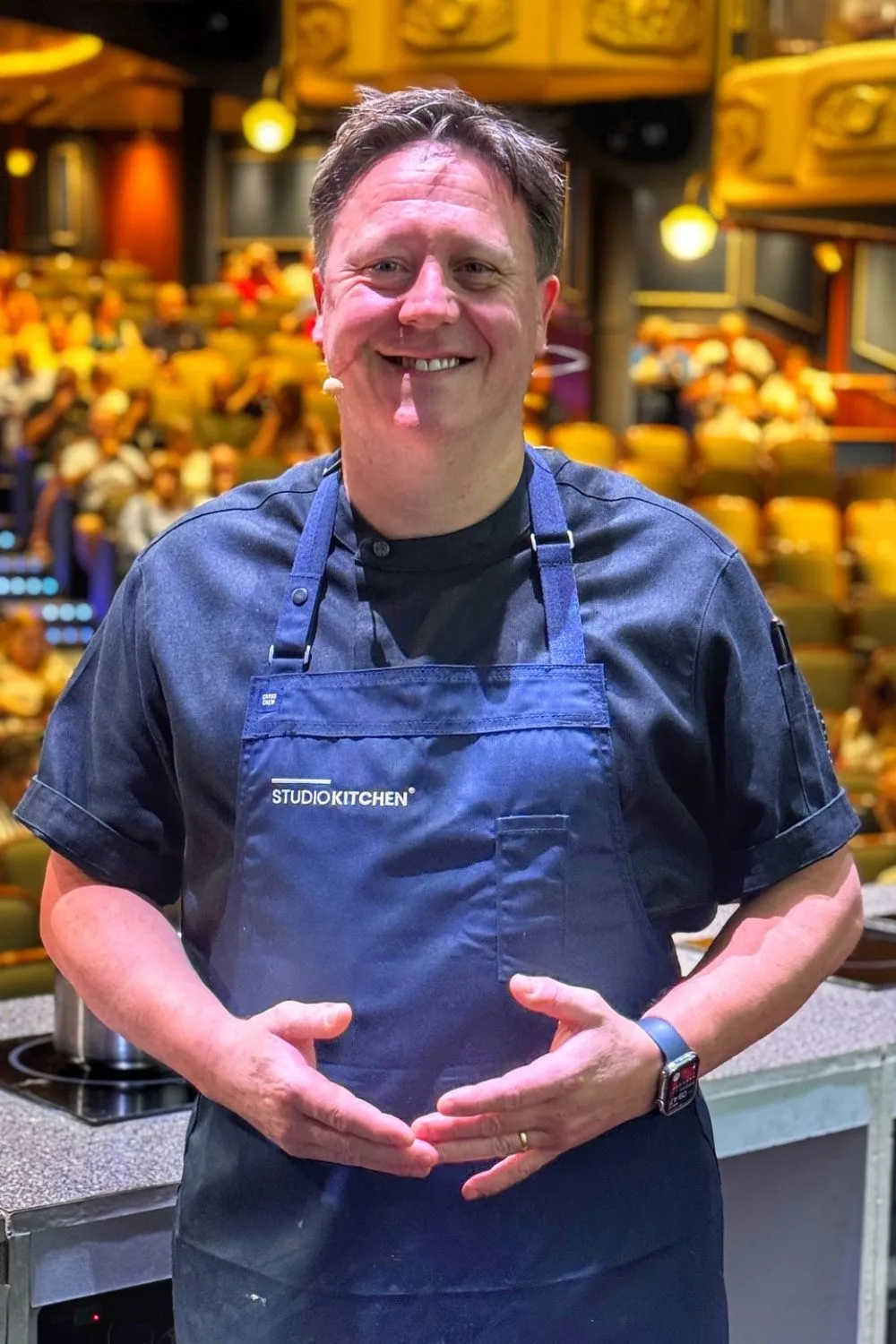 Darren Purchese wears a Studio Kitchen apron during an event