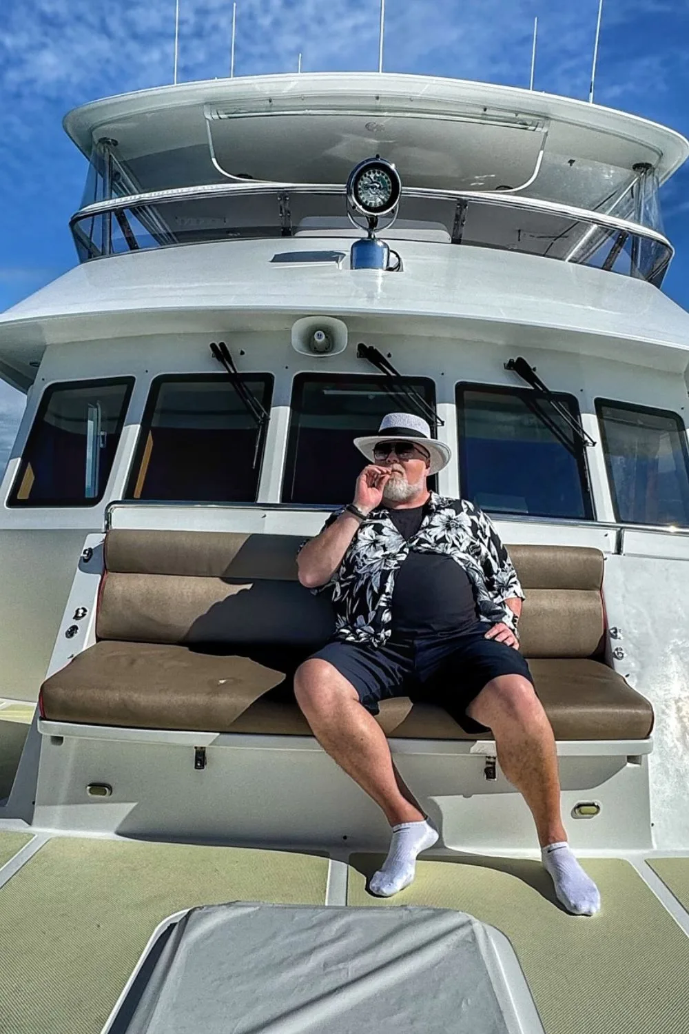 Kyle Sandilands pictured on a boat smoking a cigar
