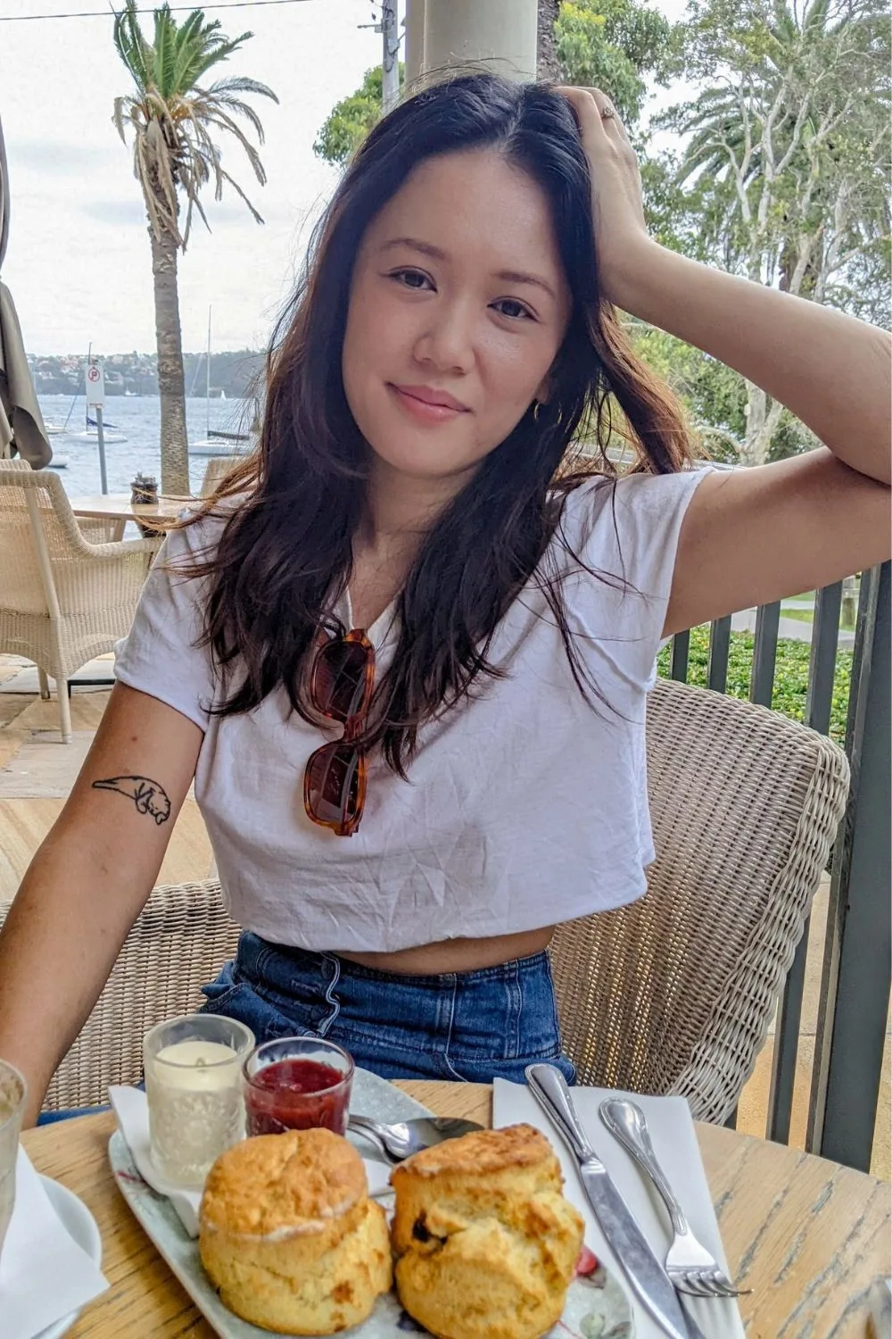 Natalie Tran sits at a cafe with scones in front of her