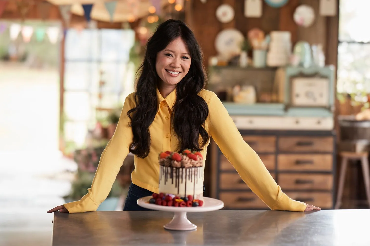 Natalie Tran poses with a delicious cake on the set of The Great Australian Bake Off