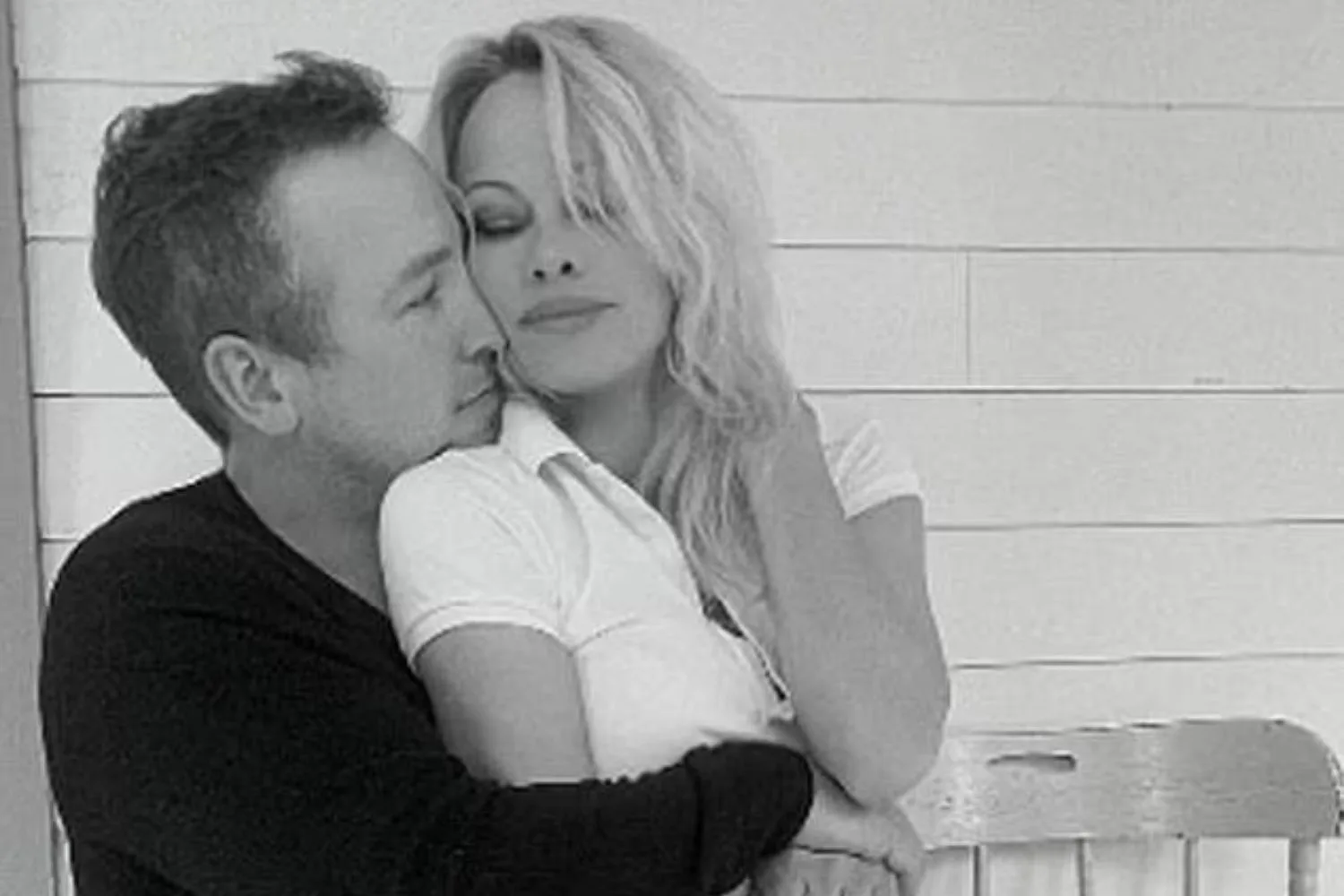 Pamela Anderson sits on Dan Hayhurst's lap in a black and white photo