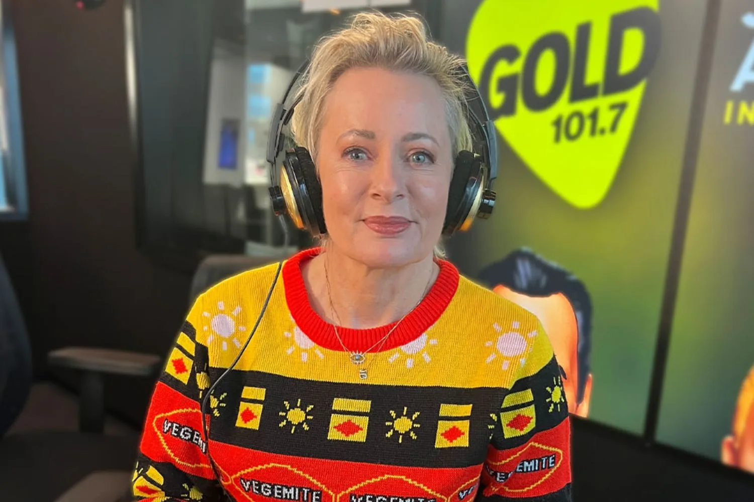 Amanda Keller wearing a Vegemite jumper with earphones on