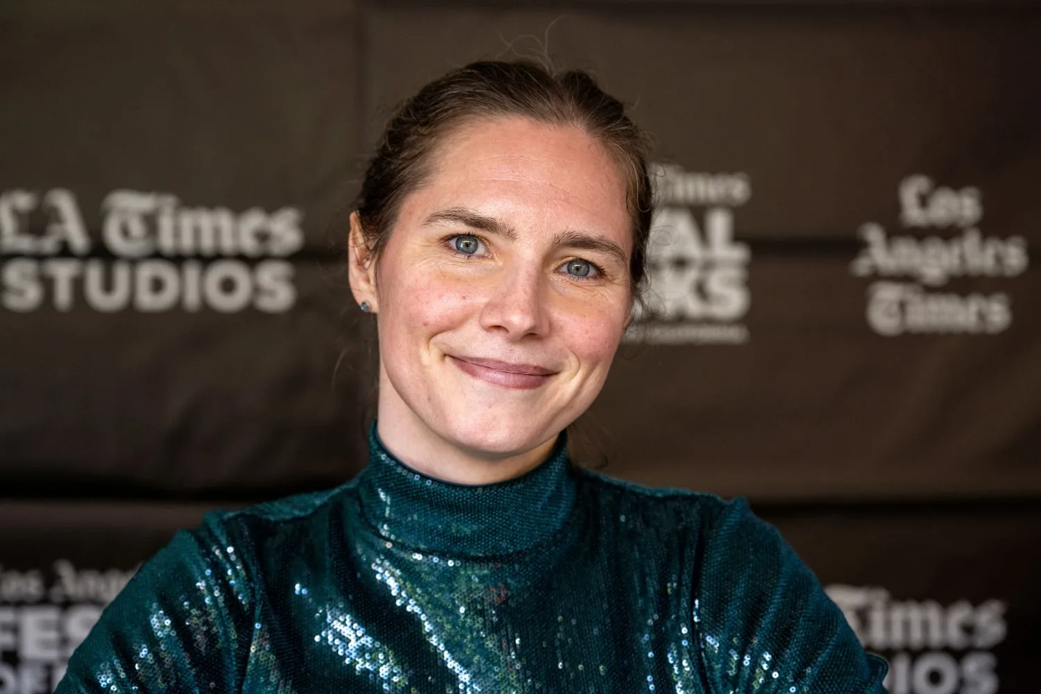 Amanda Knox smiles at the camera in a glittering outfit at an event