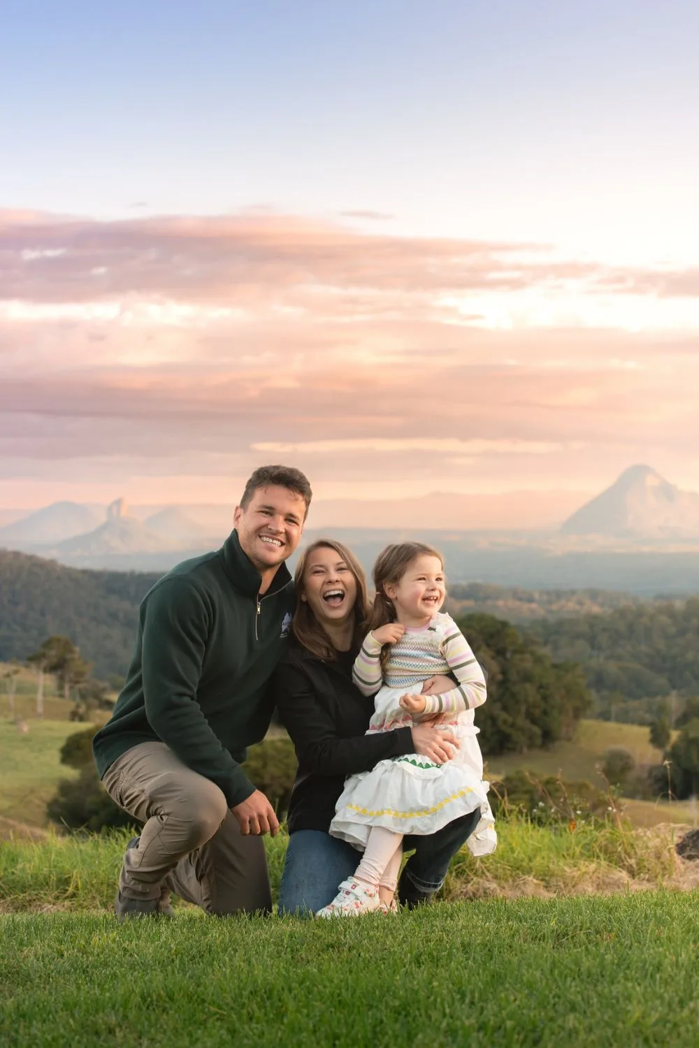 Bindi Irwin with husband Chandler and daughter Grace embracing in a field