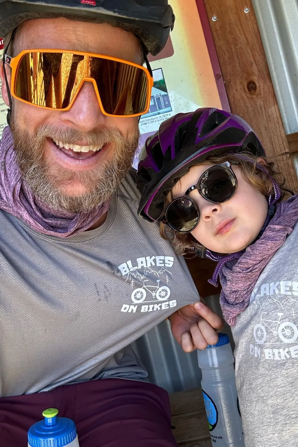 Hamish Blake in cycling gear with one of his children