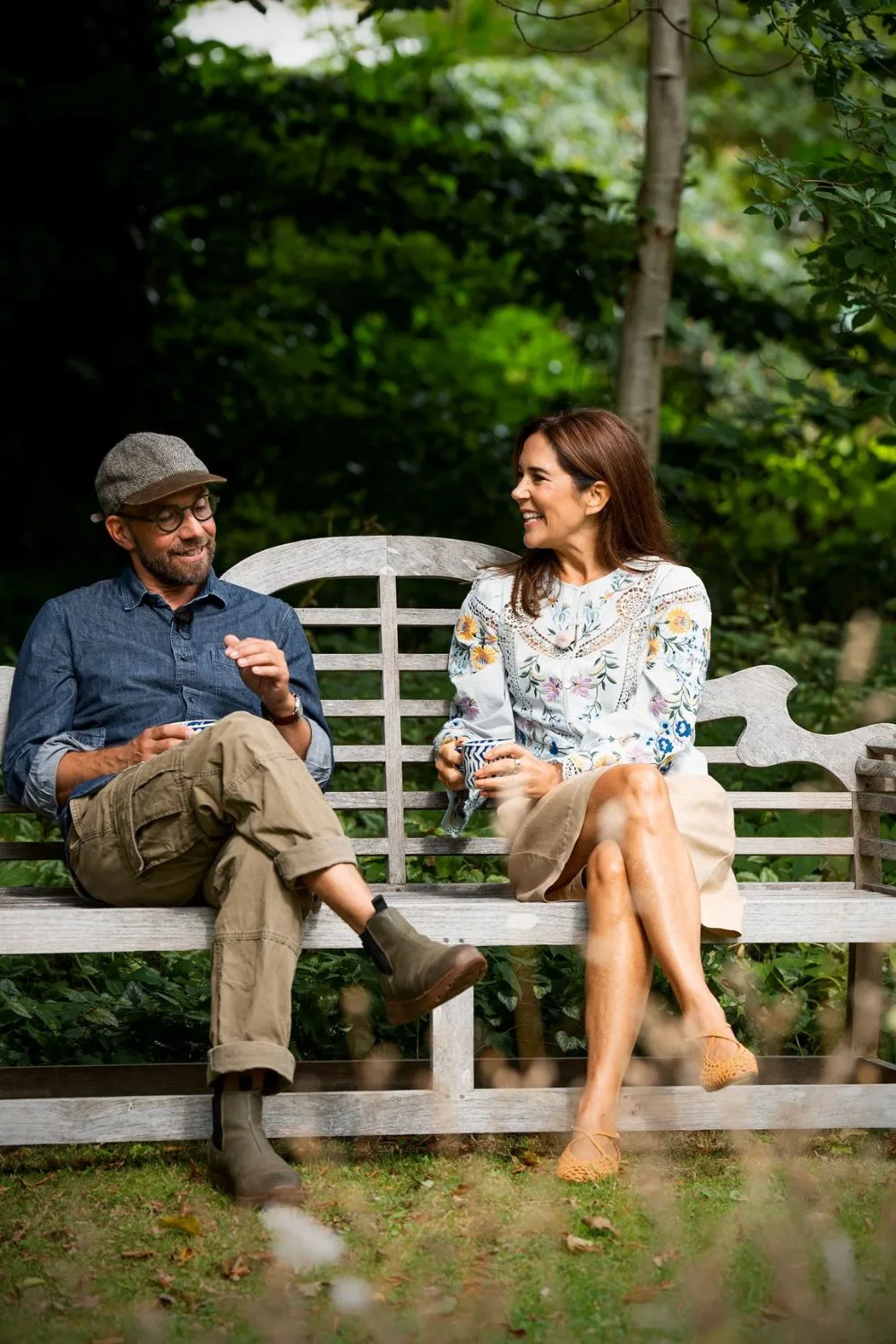 Queen Mary chats to Søren Vester on a wooden bench