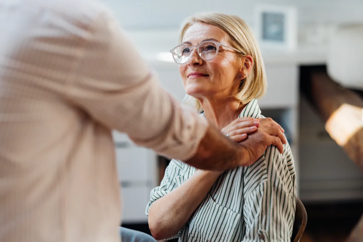 Supportive hand on woman's shoulder