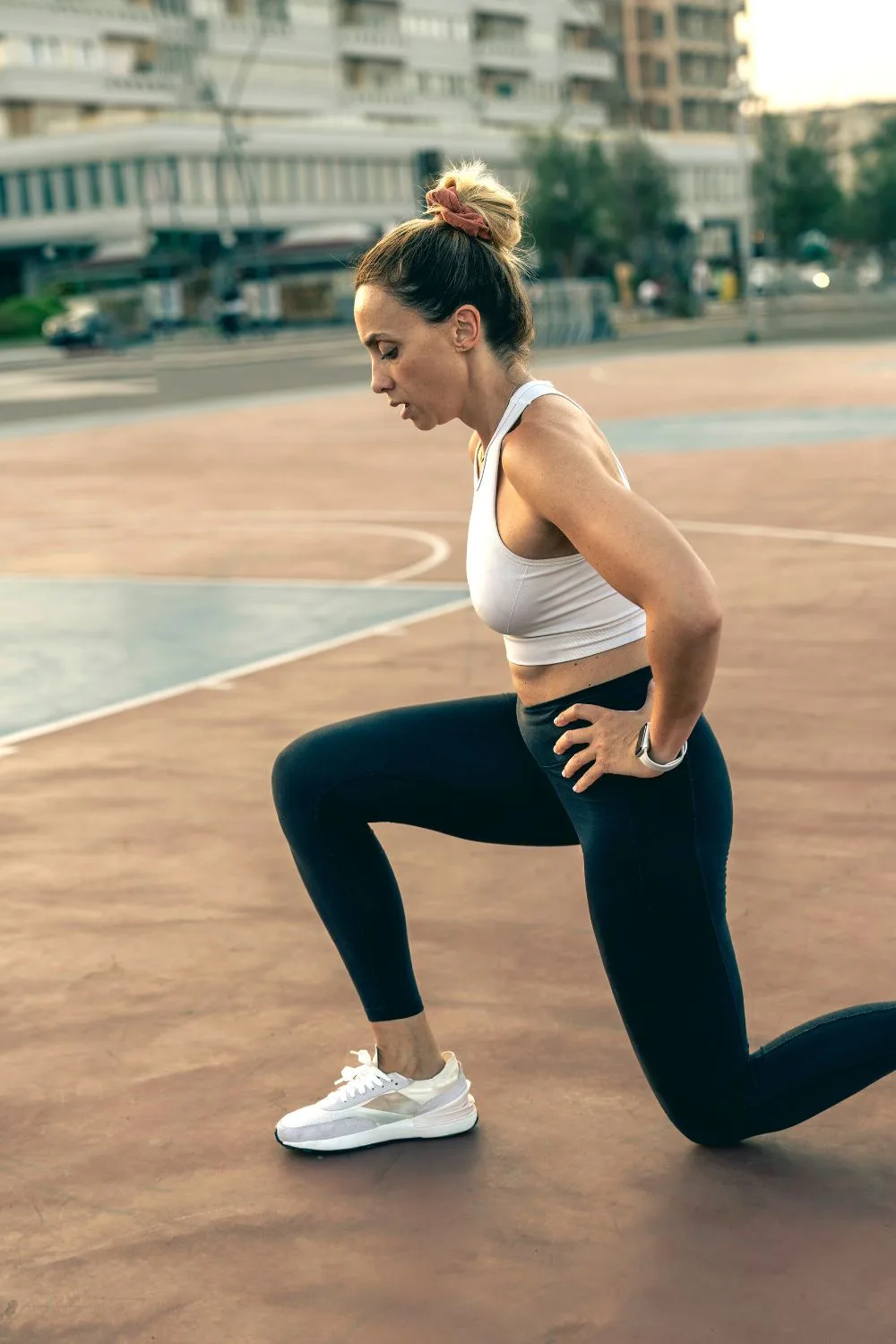 Woman stretching in outside court wearing activewear