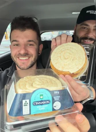 Social media creators Nick Vavitis and nectoriouspapi review the Cinnabon cake at Woolies.