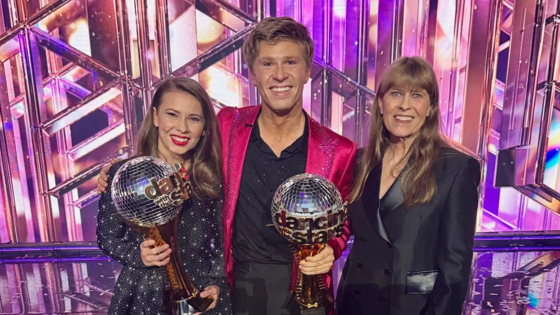 Bindi Irwin and Robert Irwin holding Dancing with the Stars trophies after the grand final in 2025, with mum Terri Irwin