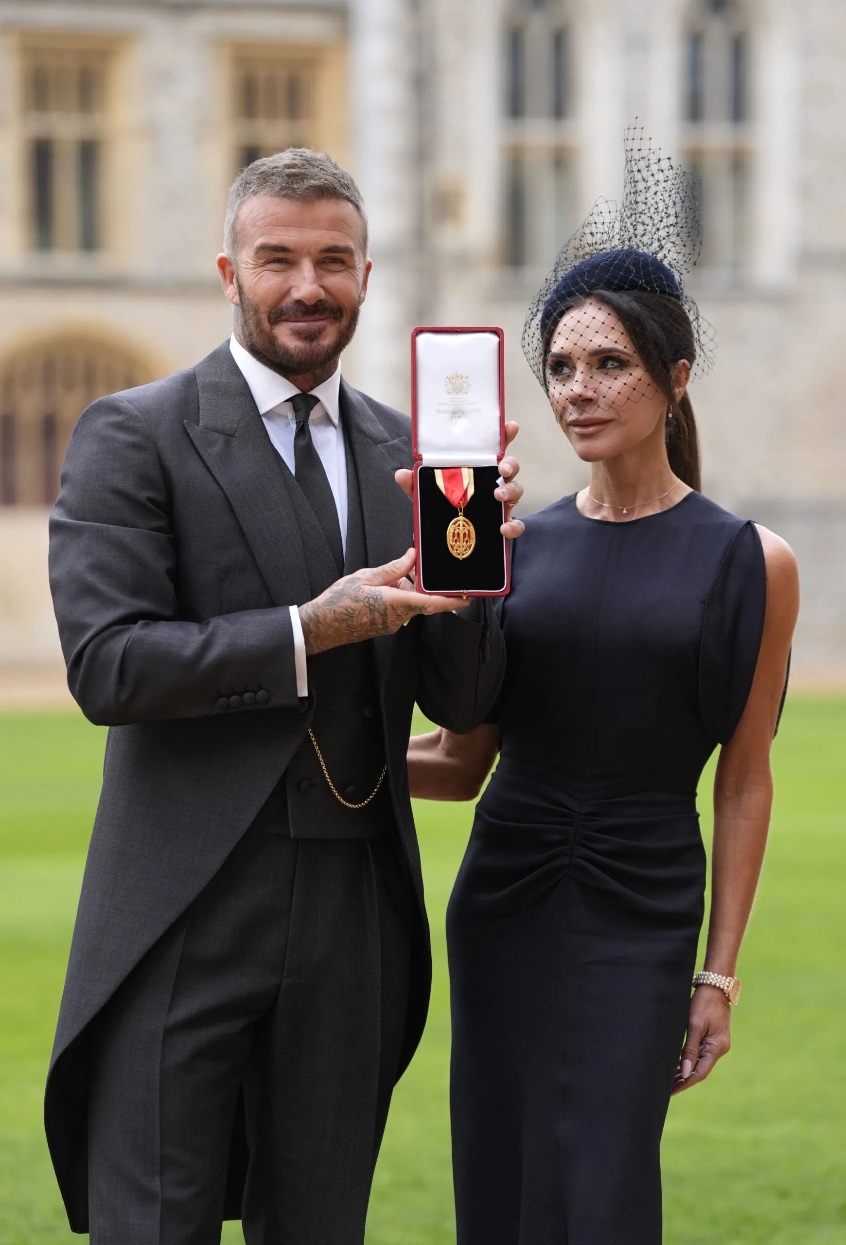 David Beckham and Victoria Beckham with his knighthood medal 