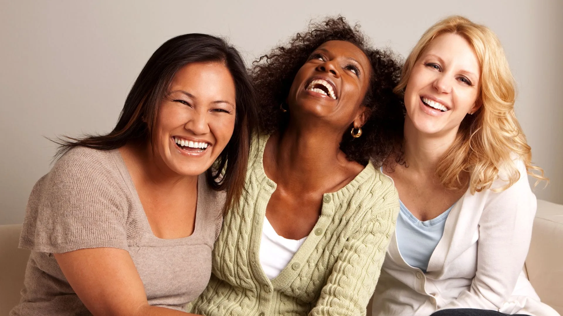 three women laughing together 