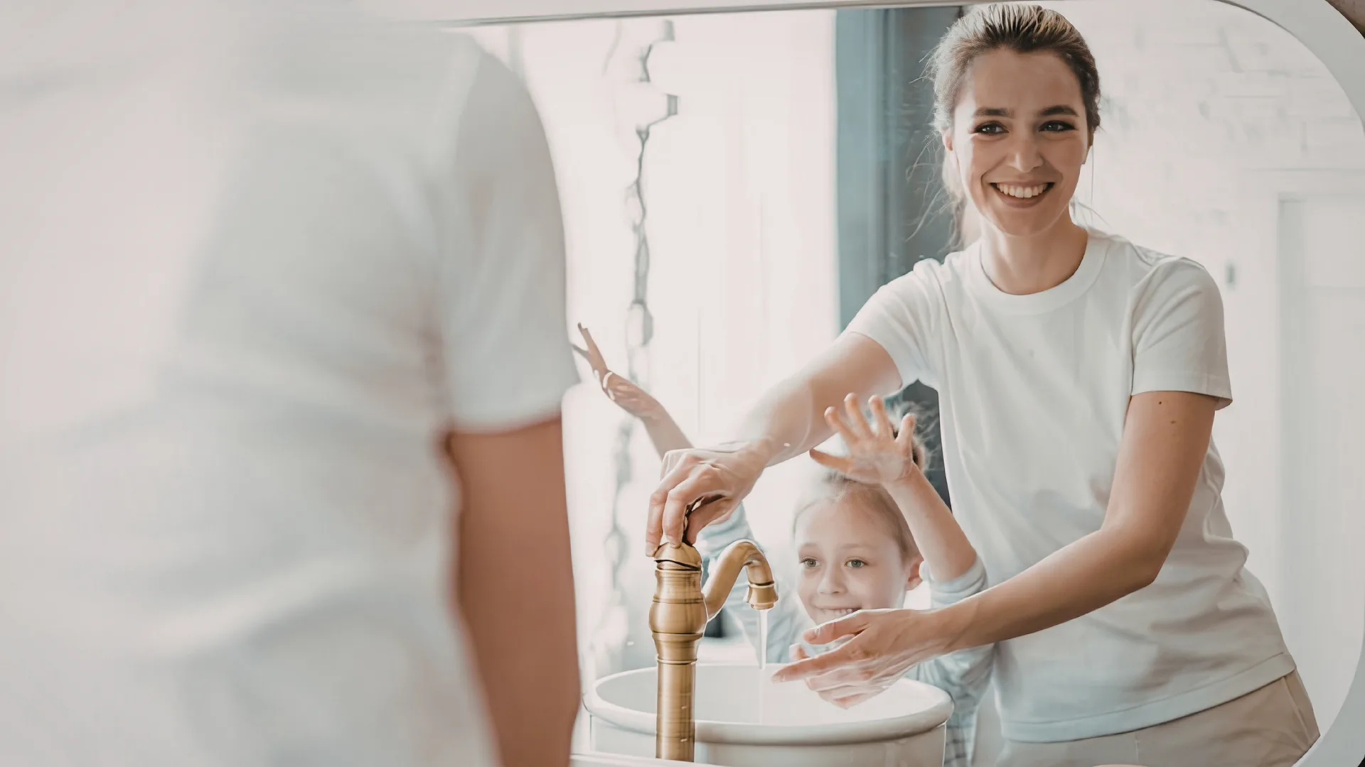 Woman and child washing hands together.