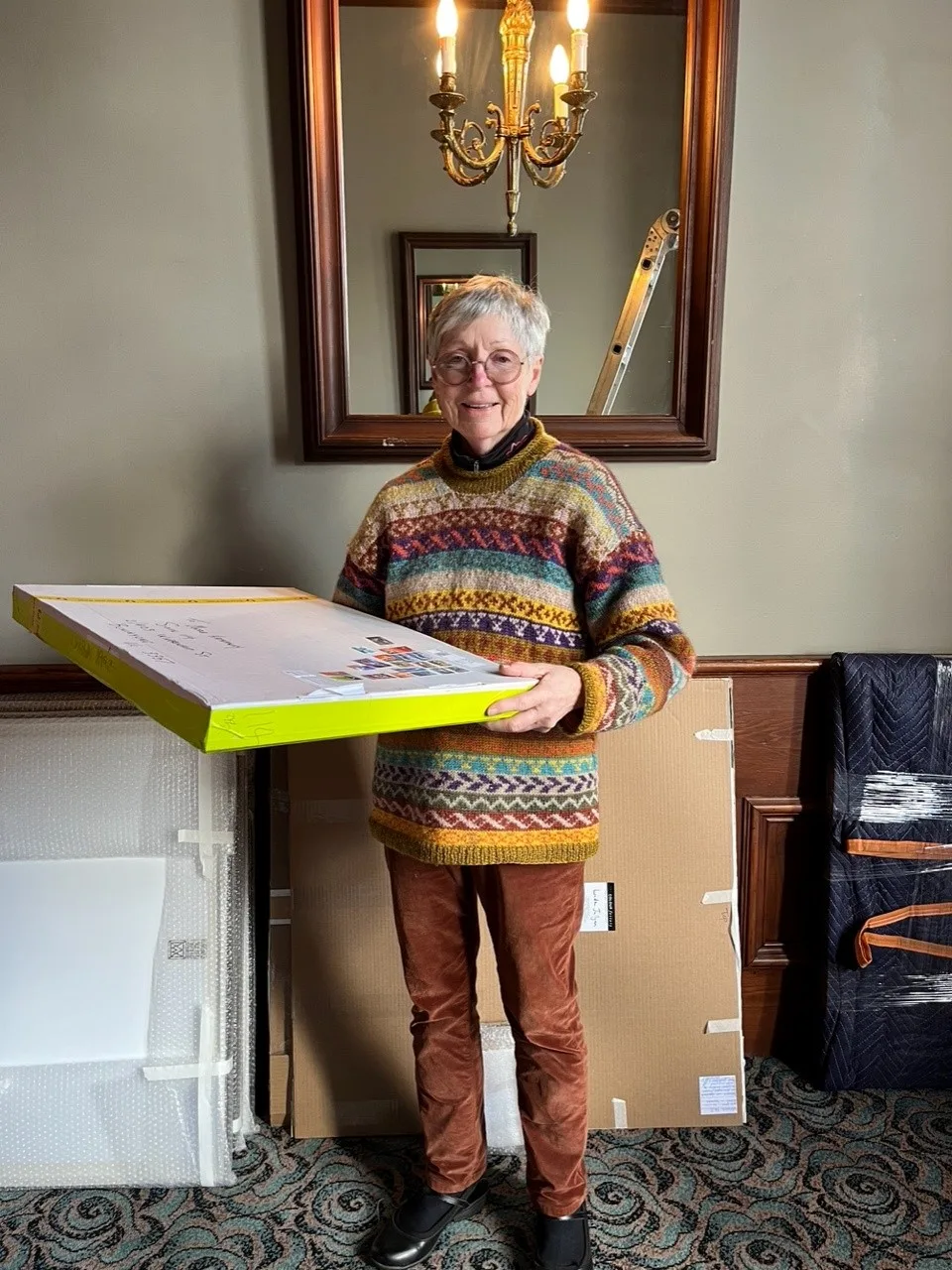 Merle Hathaway receiving one of her artworks from her exhibition