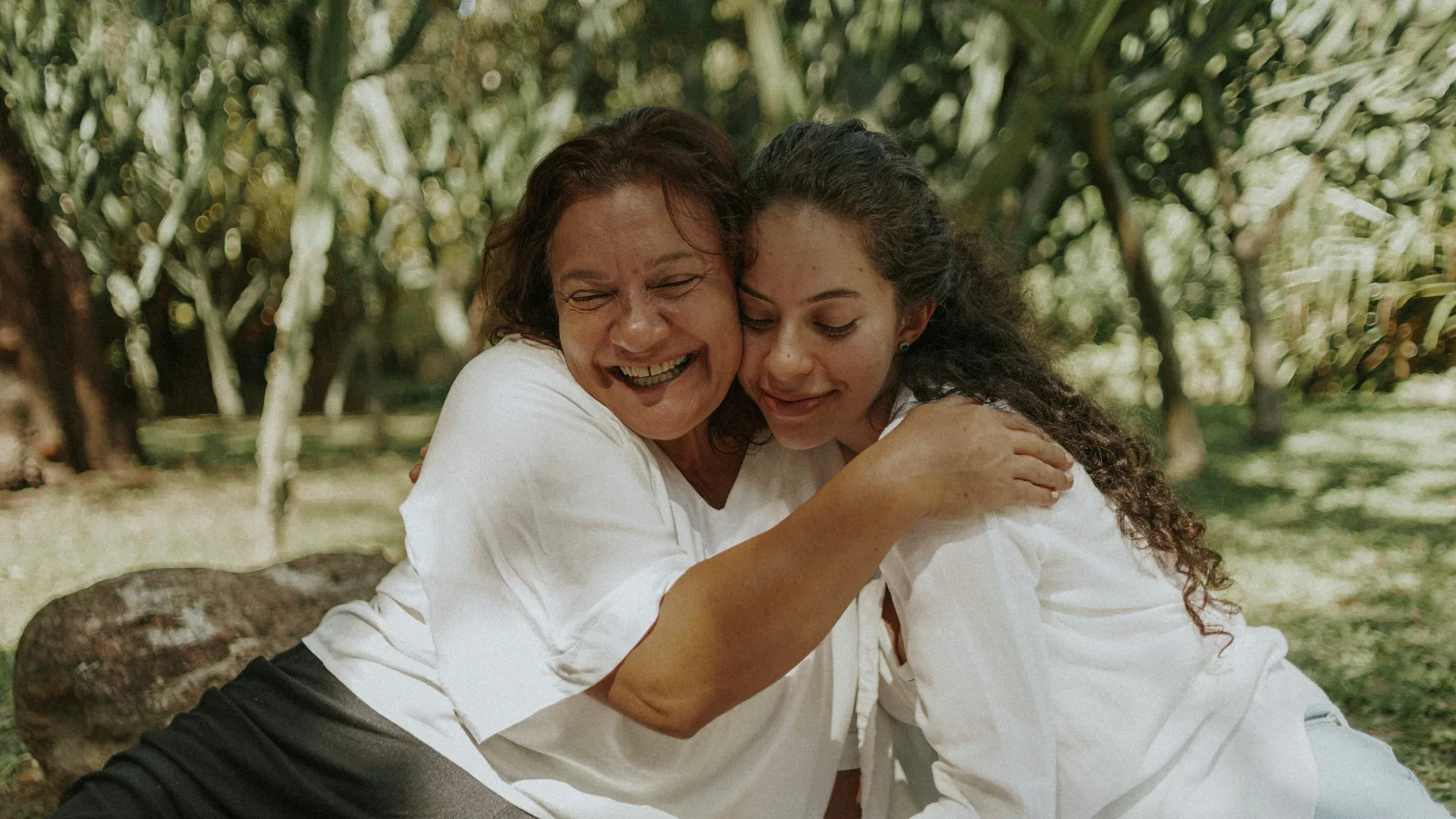 mother and daughter hugging in outdoor area
