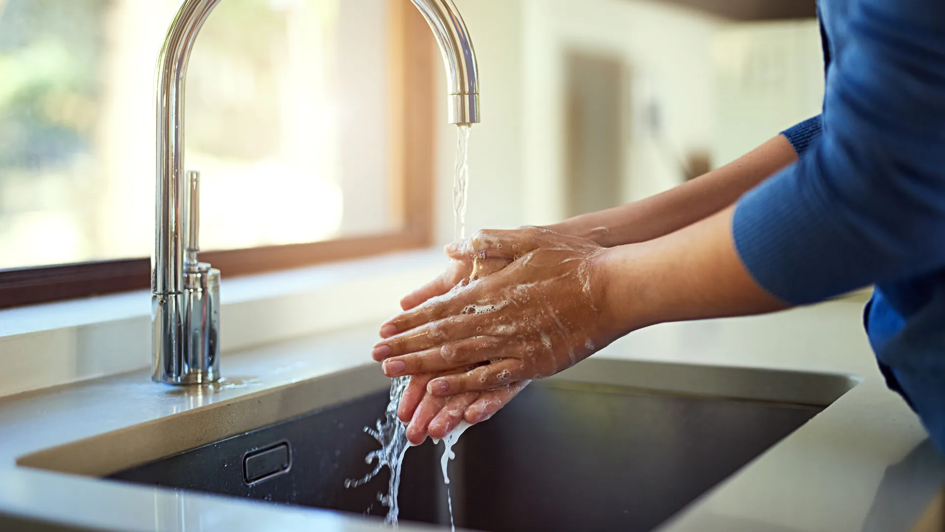 woman washing hands in sink