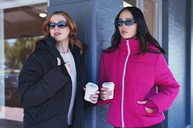 two women wearing oodie black puffer jacket and pink puffer jacket
