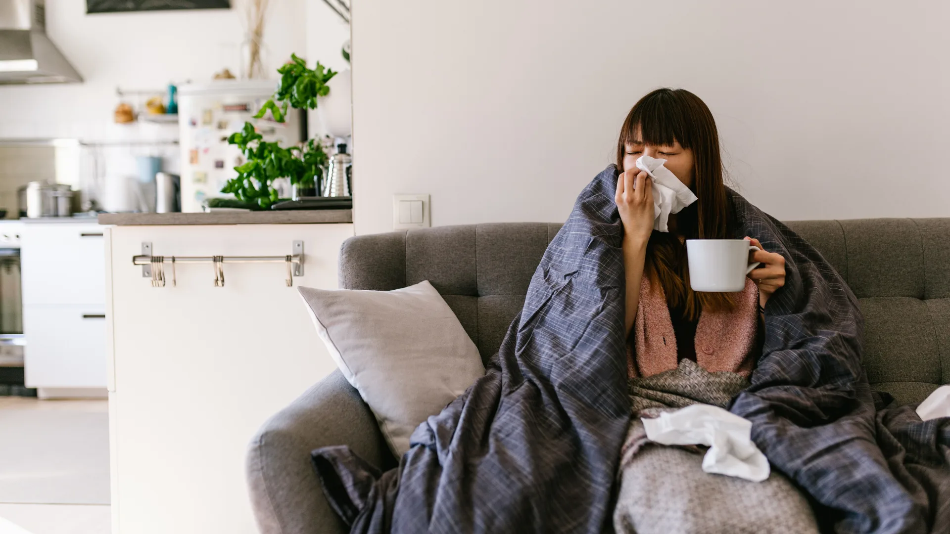 Woman with cold blowing into tissue