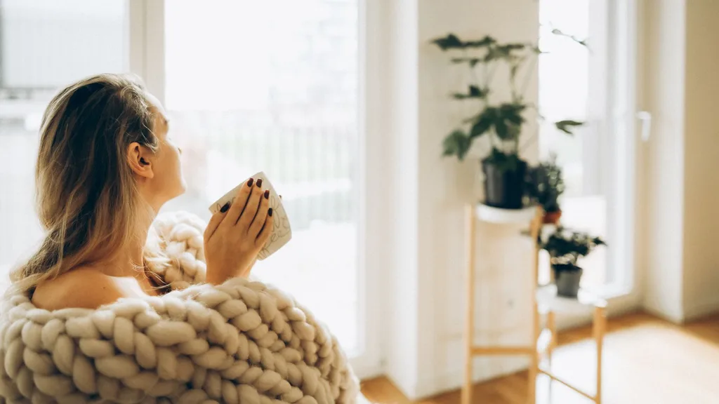 Woman at home staying warm, natural light