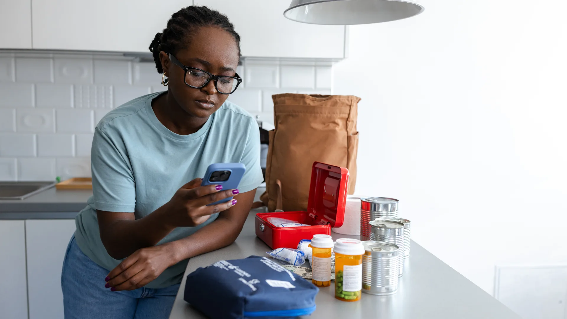 woman auditing her first aid kit at home