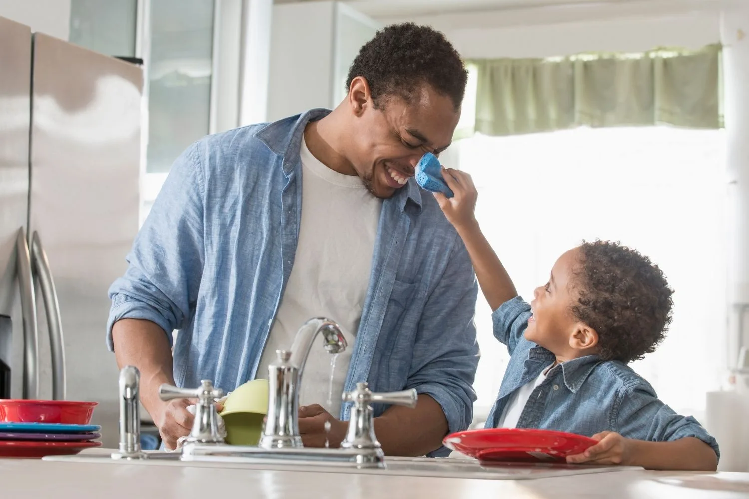 A man and his son clean in their kitchen