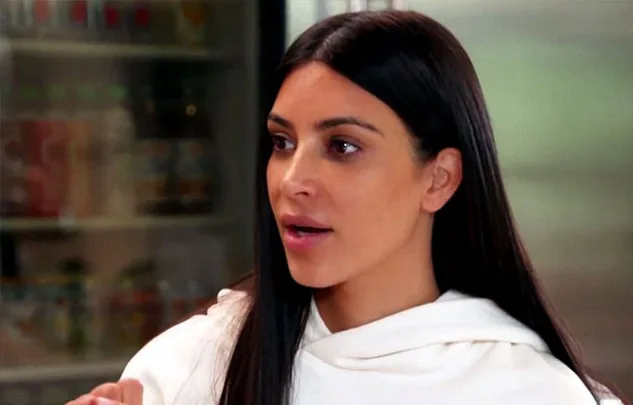 A person with long dark hair wearing a white top appears to be speaking in a candid moment.