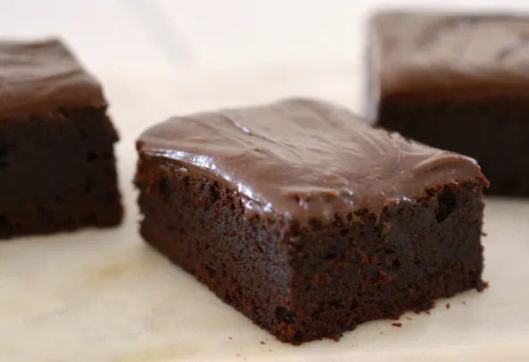 Rich, chocolate-frosted Milo brownies on a light background.