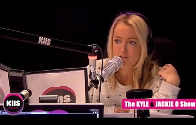 Radio host speaking into a microphone on The Kyle & Jackie O Show on KIIS 1065.